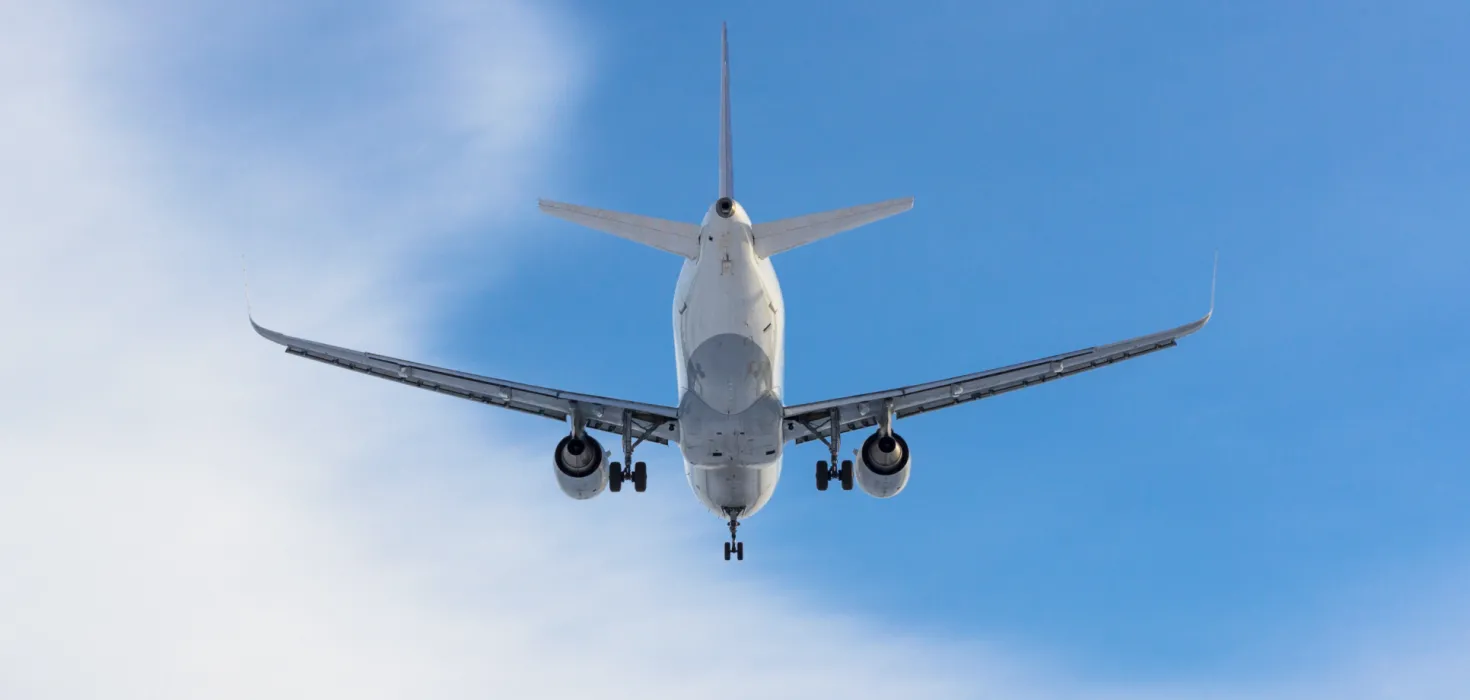 Aufnahme von unterhalb eines Flugzeugs in den blauen Himmel