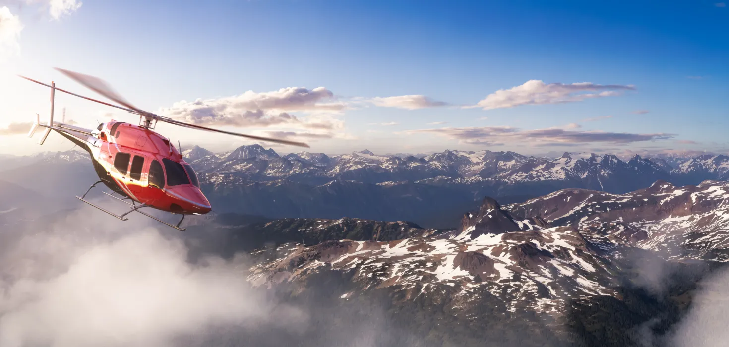 Helicóptero sobrevolando las montañas nevadas