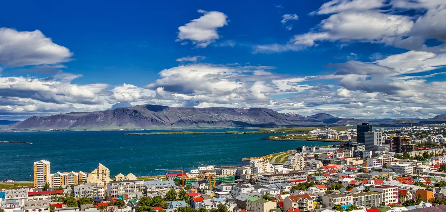 Loftmynd af Reykjavík, litrík þök og fjöll allt í kring