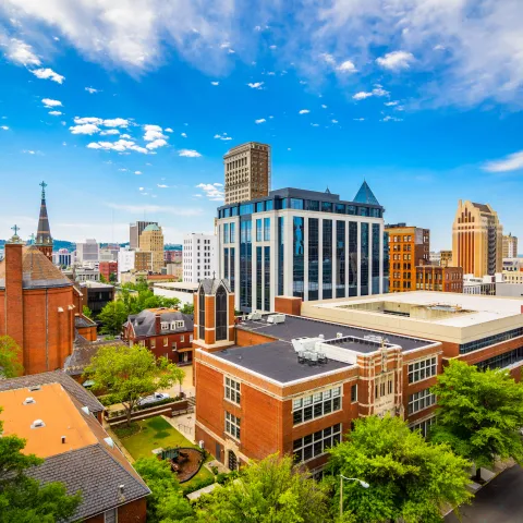 Cityscape of Birmingham with high buildings surrounded by green trees